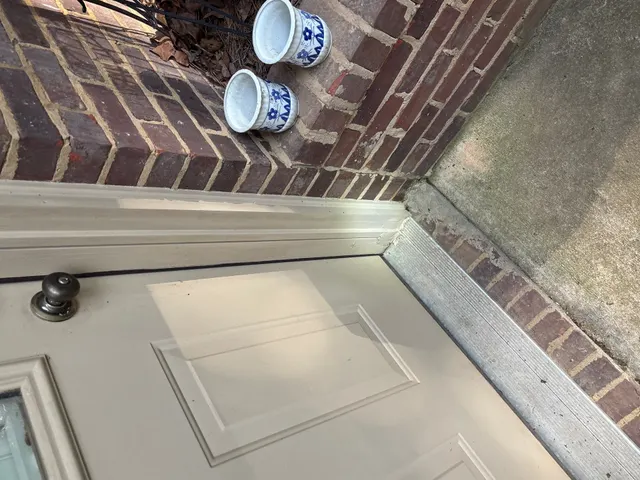 APS Foundation Repair and Waterproofing inspecting concrete expansion joint separation at a residential doorway