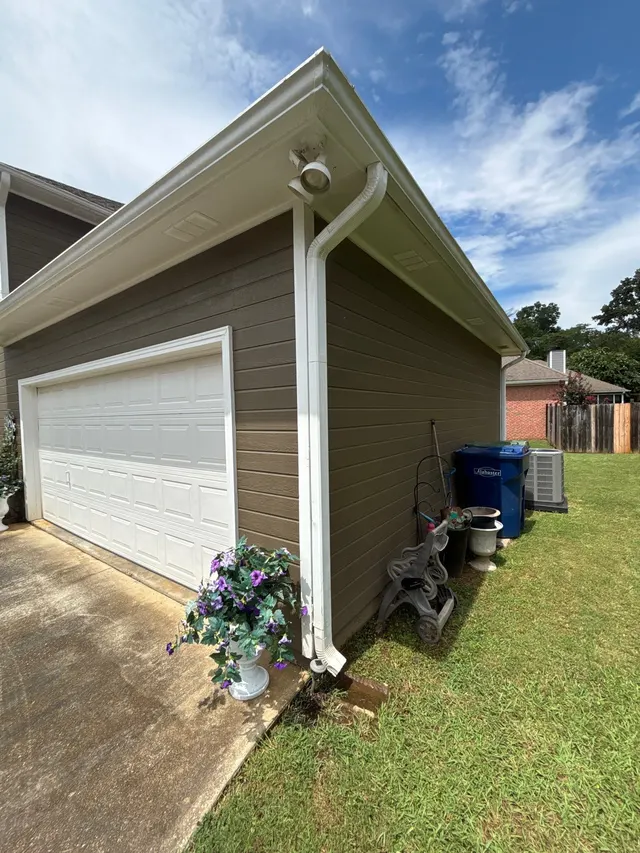 APS Foundation Repair and Waterproofing observing poor downspout drainage at a residential foundation in Helena, AL