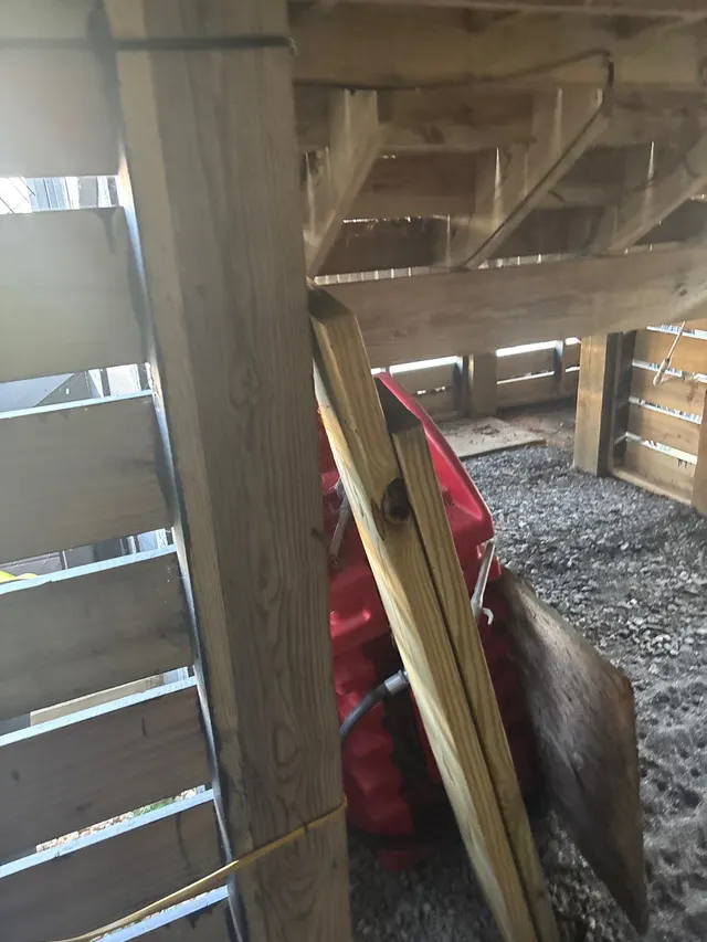 APS Foundation Repair and Waterproofing showing the wooden beams and floor joists of a crawl space structure under a house
