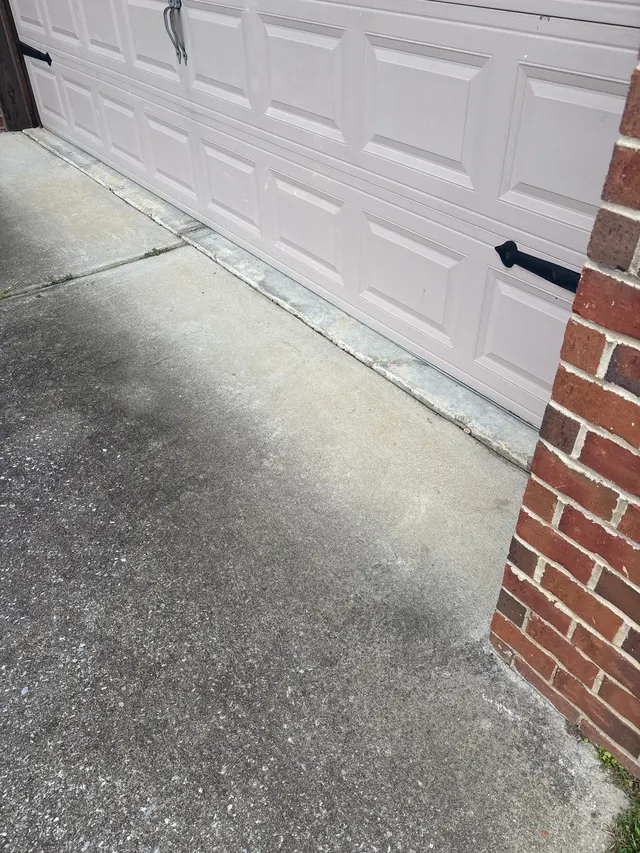 APS Foundation Repair and Waterproofing inspecting a cracked and uneven concrete driveway at a garage in Westover, AL.