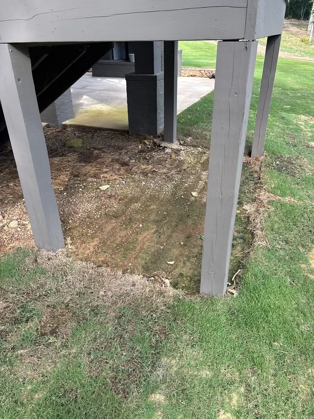 APS Foundation Repair and Waterproofing inspecting foundation water signs from standing water under a deck in Westover, AL.