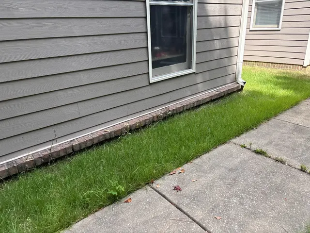APS Foundation Repair and Waterproofing inspecting foundation settlement and cracked sidewalk at a residential exterior