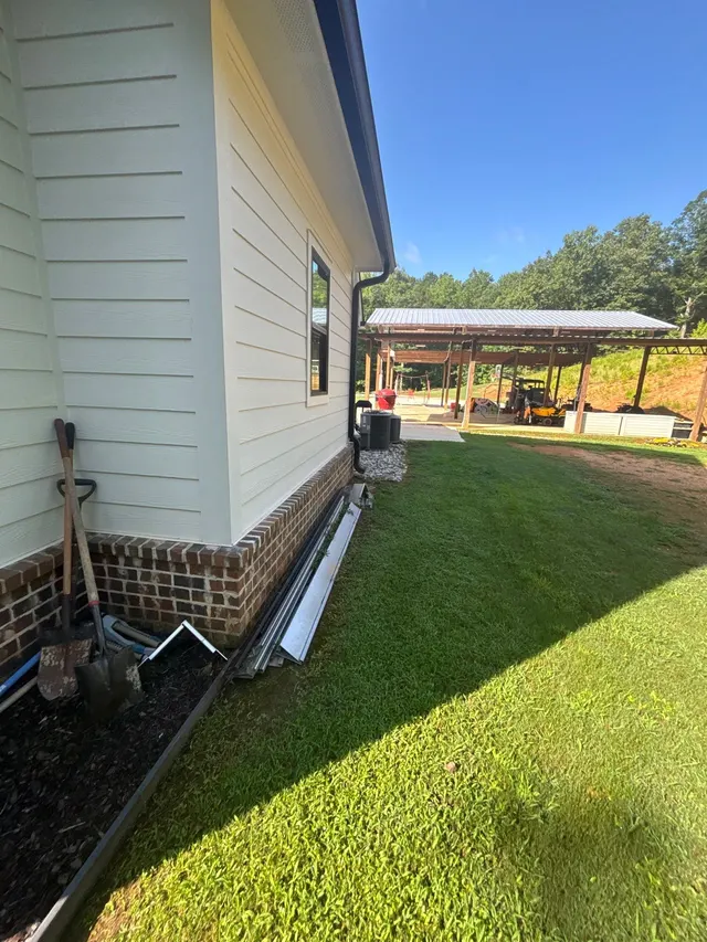 APS Foundation Repair and Waterproofing preparing for gutter installation on a residential exterior in Columbiana, AL.