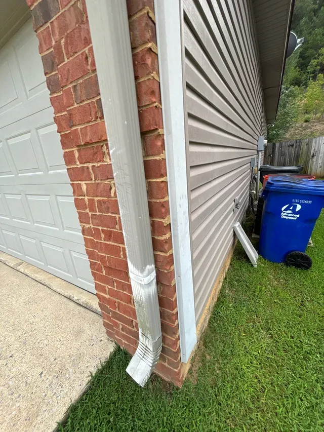 Eroded Soil Under Downspouts on an Alabama home, photographed on an APS job site