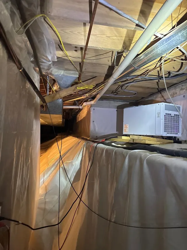 APS Foundation Repair and Waterproofing installing a vapor barrier and dehumidifier for crawl space moisture control